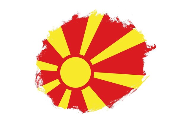 Pincel de trazo de mancha redondeada con textura de bandera nacional de Macedonia del Norte sobre fondo blanco