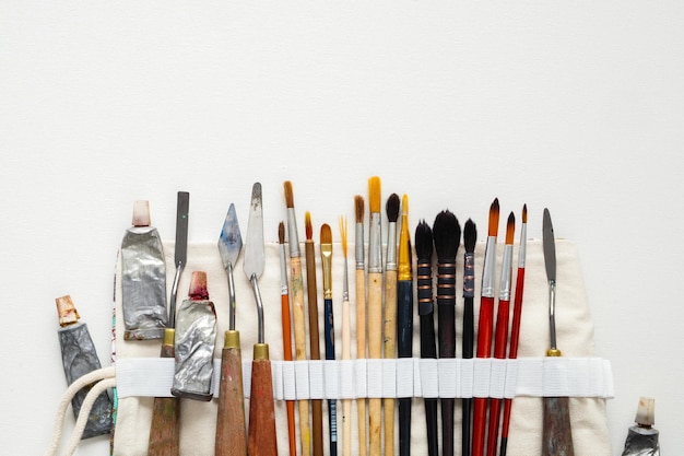 Pinceles, espátulas y tubos de pintura en una bolsa de transporte Un estuche de almacenamiento de herramientas para el trabajo del artista