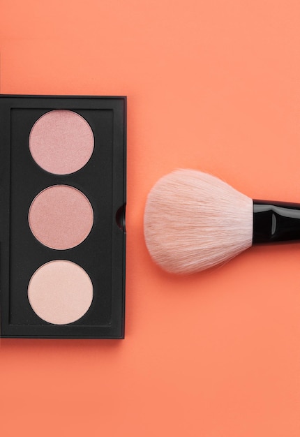 Foto pinceles de maquillaje con polvoxa sobre fondo rosa