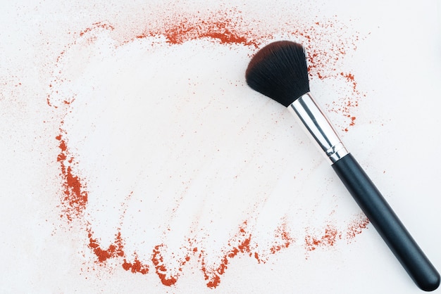 Pinceles de maquillaje sobre fondo blanco con pigmento en polvo de colores