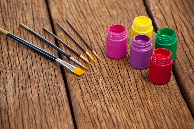 Pinceles y pinturas de acuarela sobre mesa de madera