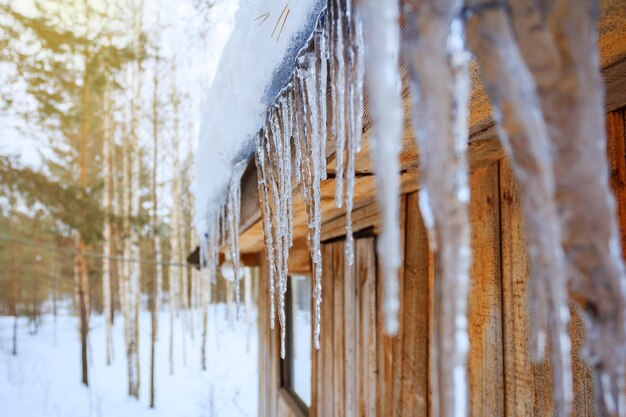 Pingentes de gelo pendurados em um telhado no inverno