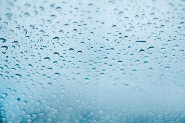 Pingos de chuva na janela Gotas de água no vidro Tom azul