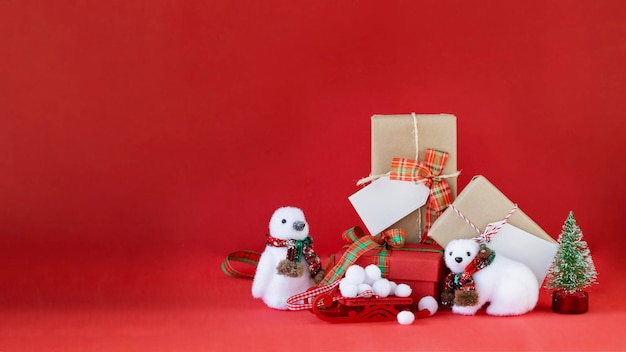 Pinguim branco e urso polar com muitos presentes de natal em fundo vermelho