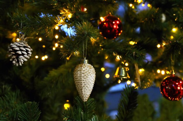 Pinha na árvore de Natal com guirlanda em fundo escuro. Efeito bokeh para o ano novo