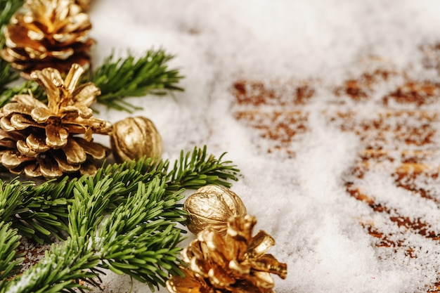 Pinha pintada dourada na mesa de neve, decoração de Natal