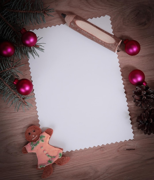 Foto pinhas de cartão de natal em branco e lápis em background de madeira