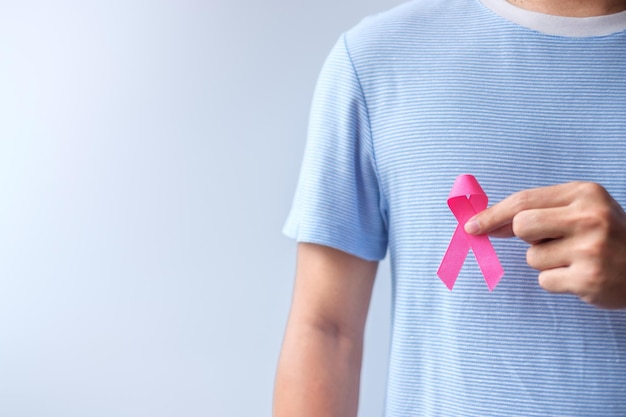 Pink Oktober Breast Cancer Awareness Month Mann hält rosa Schleife zur Unterstützung von Menschen Leben und Krankheit National Cancer Survivors Month Mother and World Cancer Day Concept