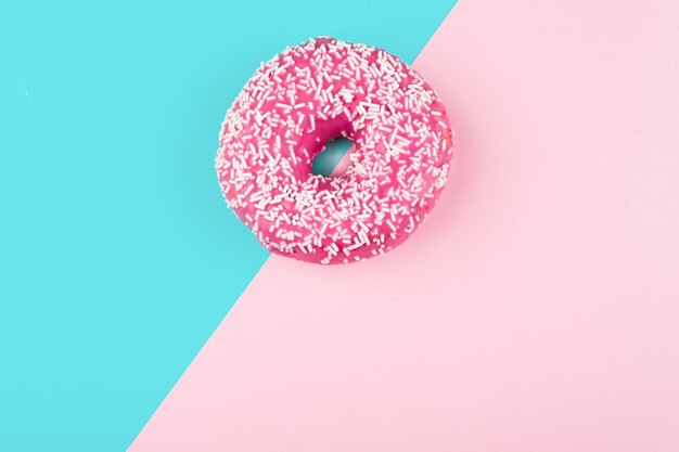 Foto pinker donut auf farbigem hintergrund