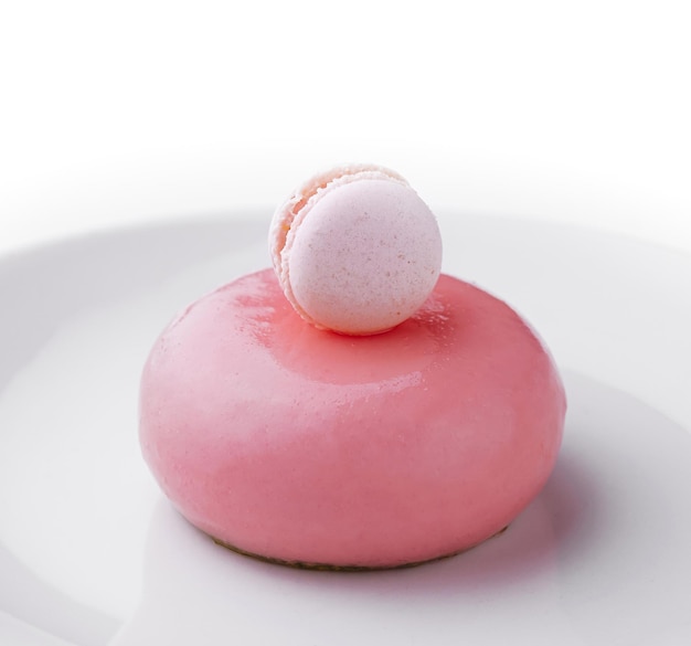 Foto pinker mousse-kuchen mit weißen makaronen geschmückt