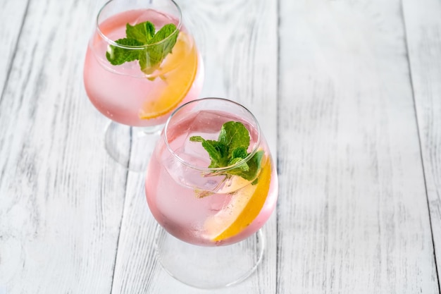 Pinker Wodka-Limonade-Cocktail garniert mit Zitronenscheibe