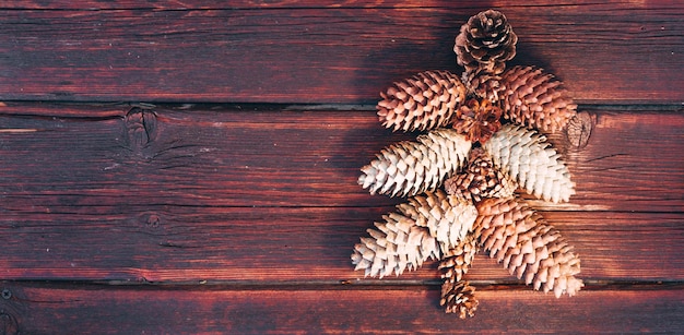 El pino se presenta sobre un fondo de madera marrón Árbol de Navidad hecho de conos