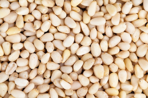 Piñones pelados de tamaño pequeño, frutos secos útiles, una parte de la cáscara permanece en las nueces de cedro.