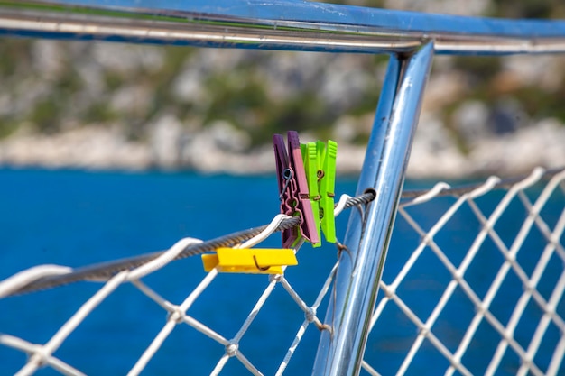 pinos coloridos presos à barreira do barco para secar toalhas e roupas na área de banho de sol