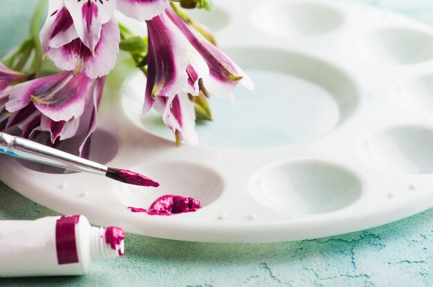 Pinsel, lila Aquarellfarbe mit Frühlingsblumen