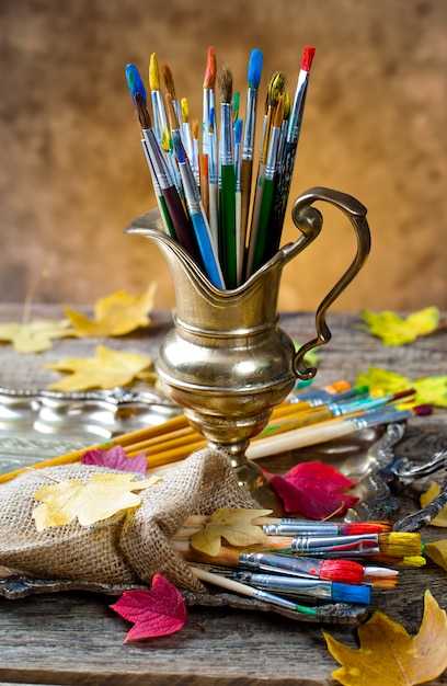 Pinsel und Farben zum Zeichnen in Komposition auf dem Tisch.