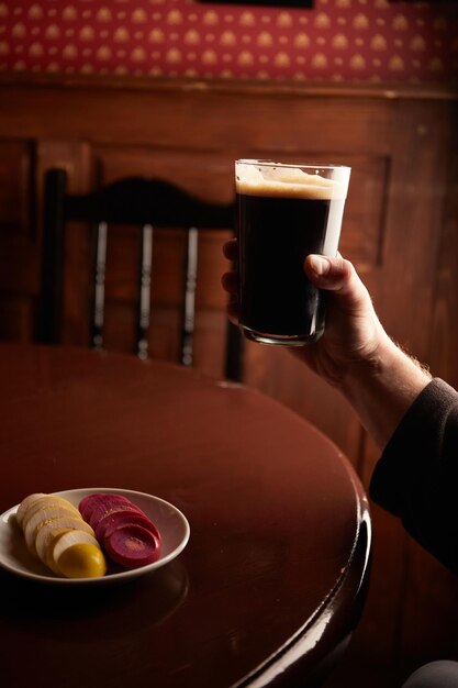 Pinta de cerveza artesanal stout en pub en mesa de madera Vaso de cerveza