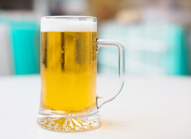 Foto pinta de cerveza en una mesa blanca en un restaurante americano