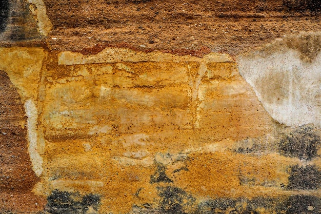 Pintado de amarelo e rachadura na velha parede de concreto da parede da cidade