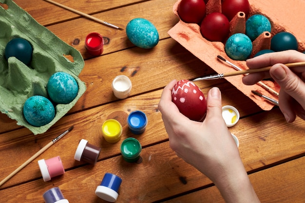 Pintando huevos. Manos de mujer pintan huevos para el día de Pascua. Preparándose para la Pascua.