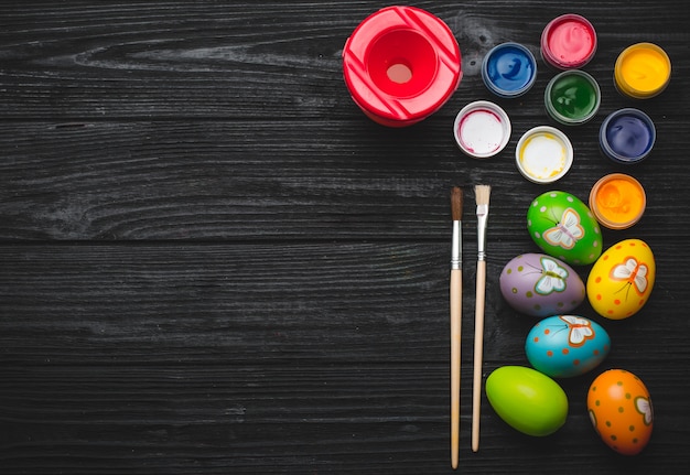 Pintando huevos para vacaciones de Semana Santa en mesa de madera.