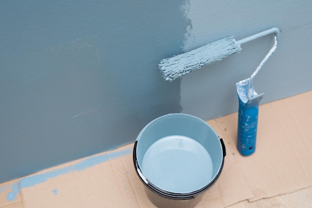 Foto pintar a parede com um rolo de cor azul
