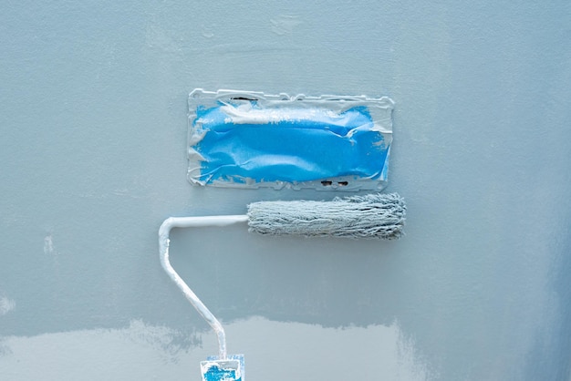 Foto pintar a parede com um rolo de cor azul