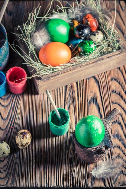 Pintar huevos de Pascua con heno y plumas.