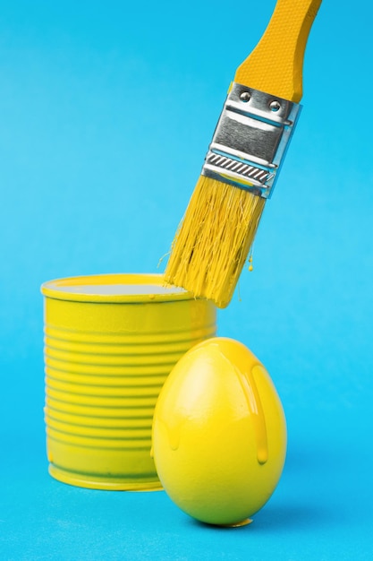 Foto pintar huevos con un pincel amarillo el concepto de la reunión de pascua minimalismo