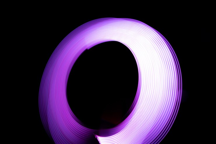 Foto pintar con luz por la noche usando luces. efecto de luz abstracta sobre un fondo negro (fotografía).