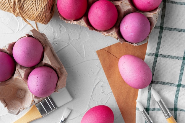 Pintar ovos de páscoa em rosa na mesa branca, ver os de cima