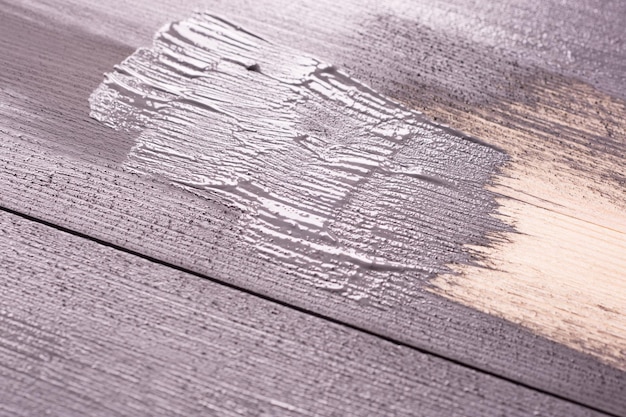 Pintar uma superfície de madeira com pincel e tinta grayxA Textura de madeira natural Renovação ou reparação de construção