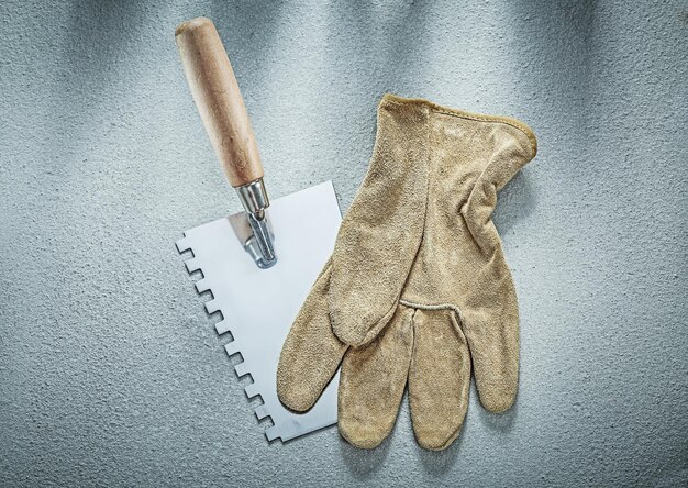 Pinte los guantes de seguridad del raspador en el concepto de construcción de superficies de hormigón.