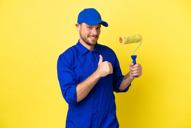 Pintor brasileiro isolado em fundo amarelo orgulhoso e satisfeito consigo mesmo