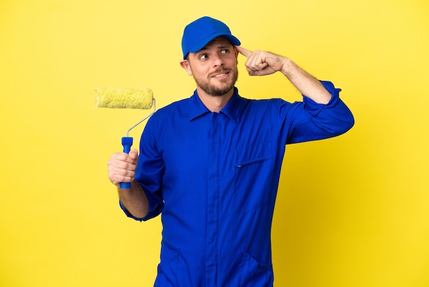 Pintor brasileiro isolado em fundo amarelo tendo dúvidas e pensando