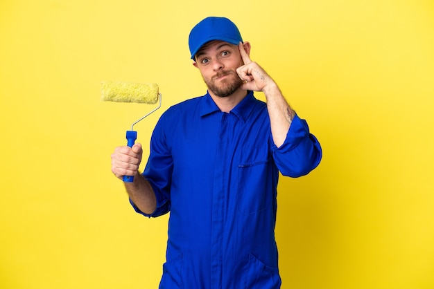 Pintor brasileño aislado sobre fondo amarillo pensando en una idea