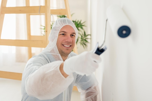 Pintor está branqueando a parede em casa. Foco seletivo. Concentre-se no fundo, no pintor.