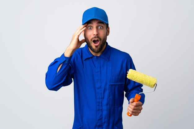 Pintor homem segurando um rolo de pintura isolado no branco percebeu algo e pretendendo a solução