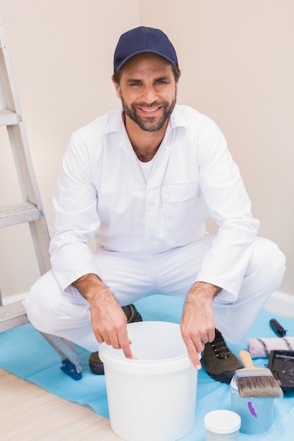 Pintor misturando tinta em um balde