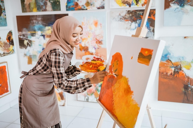 Pintor musulmán está pintando en su taller con entusiasmo