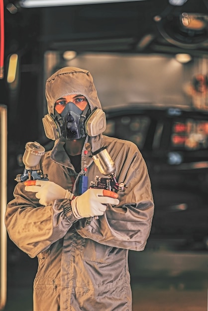 Foto pintor vistiendo un mono con pistola en la mano