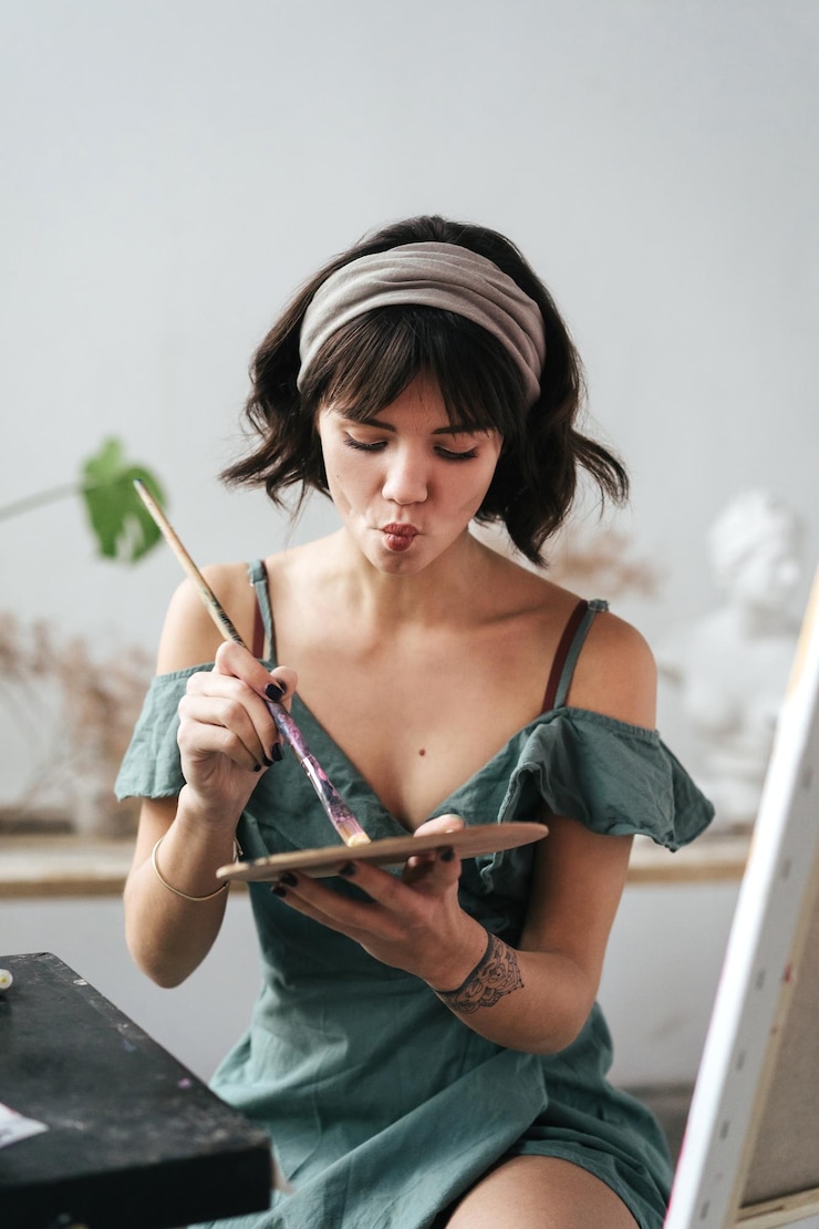 Foto pintora mezclando pintura en una paleta en un estudio de arte