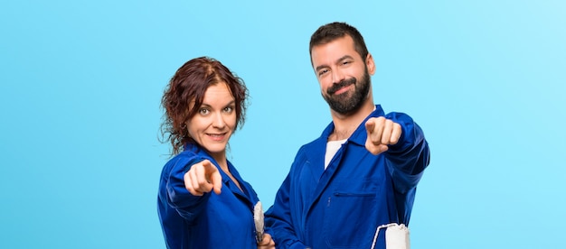 Foto pintores aponta o dedo para você com uma expressão confiante em fundo colorido