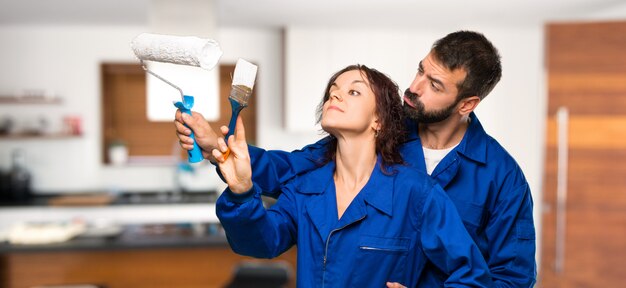 Pintores pintando una pared en casa.