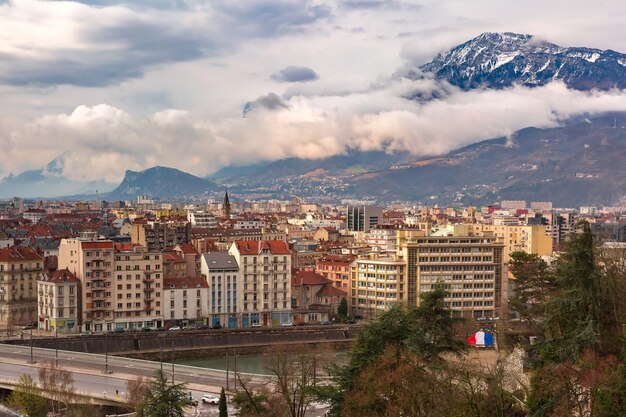 Pintoresca vista aérea panorámica de las orillas del río Isere, el puente y los Alpes franceses en el fondo, Grenoble, Francia