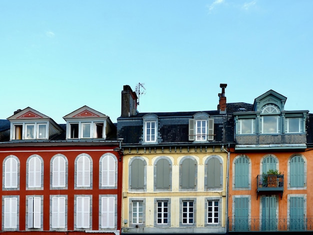 Foto pintorescas casas coloridas con ventanas y contraventanas tradicionales en las calles de bagneresdebigorre francia vibrantes fachadas antiguas foto con espacio para copiar