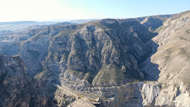 Pintorescas montañas rocosas antiguas con túnel de trinchera y pista de piedra turística vacía bajo un cielo despejado en un día soleado de verano vista panorámica