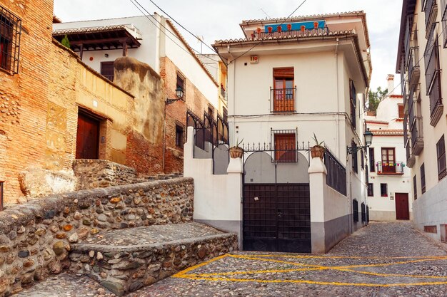 Pintoresco callejón con casas blancas tradicionales españolas en la zona del casco antiguo del Albaicín Granada Andalucía España