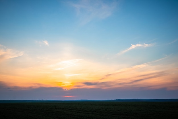 Pintoresco cielo y franja de campo durante la puesta de sol