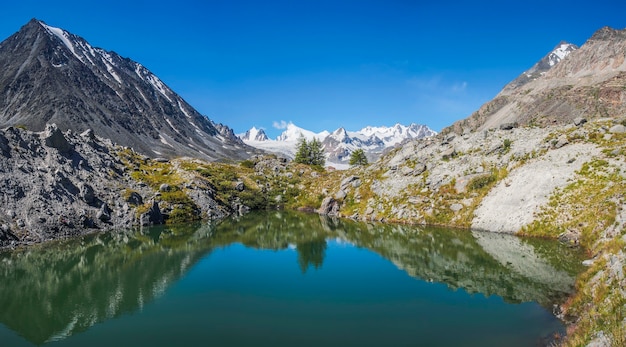 Pintoresco lago de montaña en un día soleado con reflejo